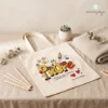 Tote bag premium de 340g para maestra personalizada con nombre de niño en un entorno escolar con material educativo.